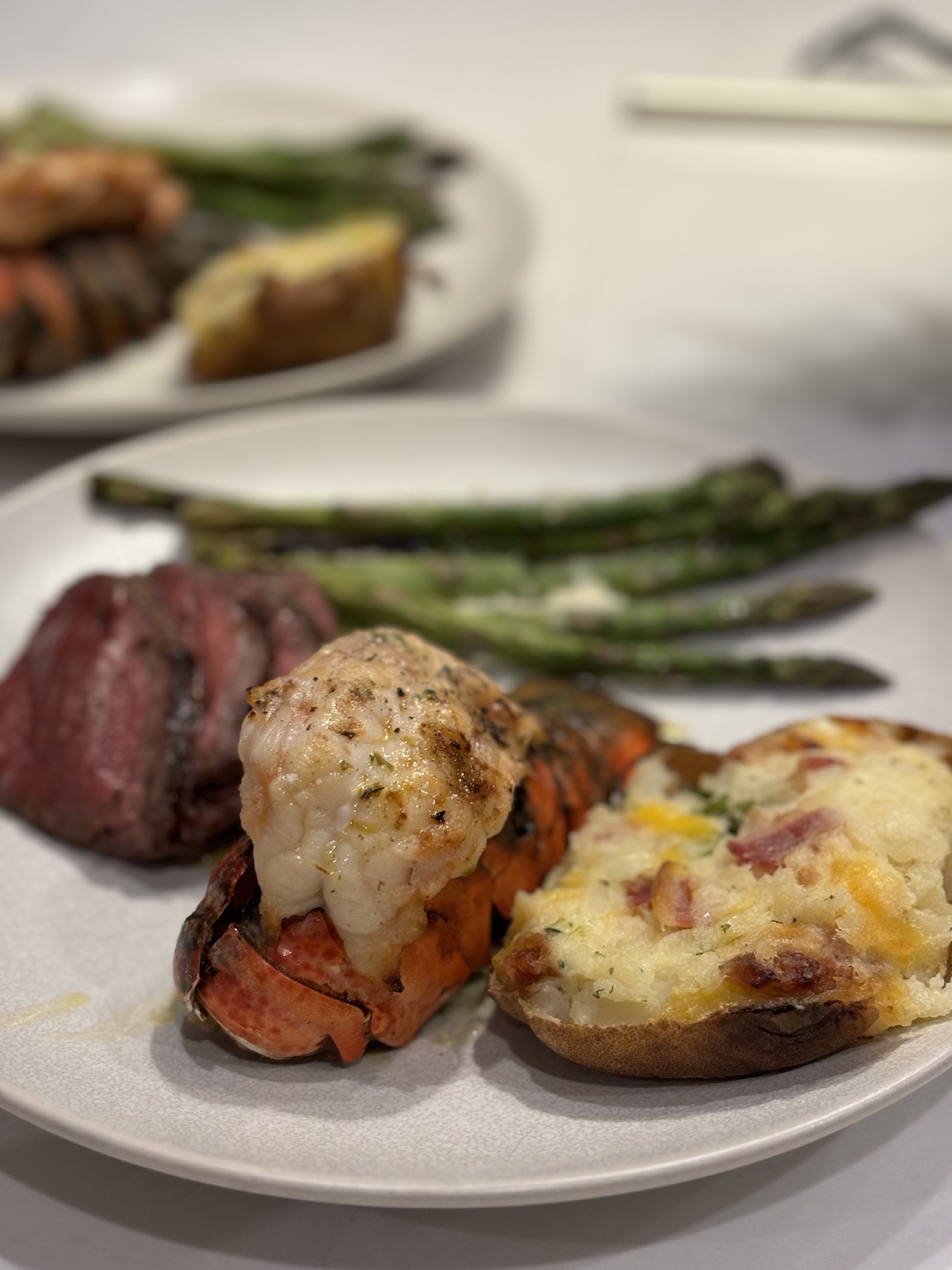 Private chef surf-and-turf dinner with lobster tail, steak, asparagus and twice-baked potato