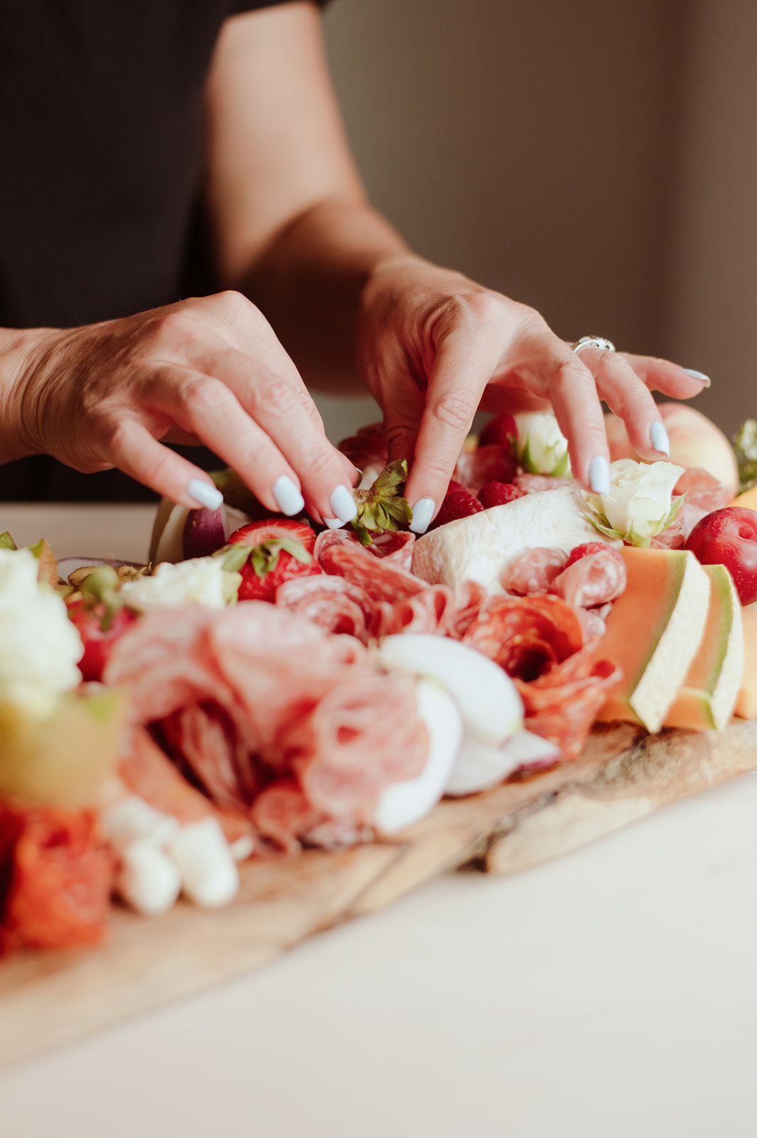 Food stylist Marissa Fisk arranging fruit and charcuterie for a camera-ready presentation